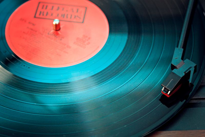 Primer plano de un disco de vinilo negro apoyado sobre una superficie clara